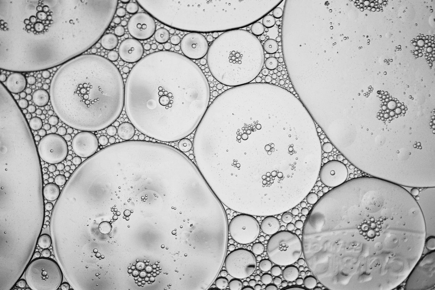Microscopic view of bubbles and fluid, showcasing intricate patterns and scientific beauty.
