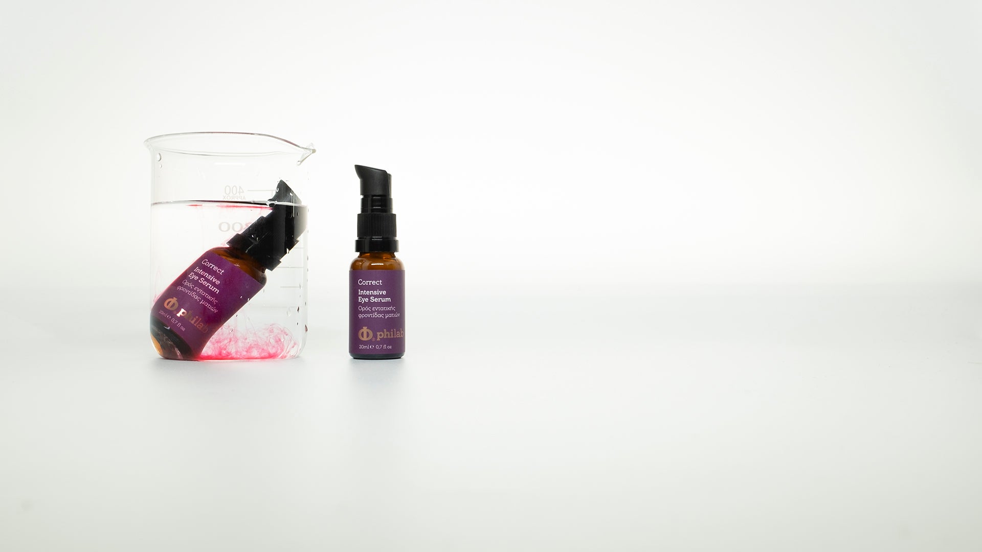 Two Philab skincare Intensive Eye Serums beside a beaker with dissolved pink contents, against a white backdrop.